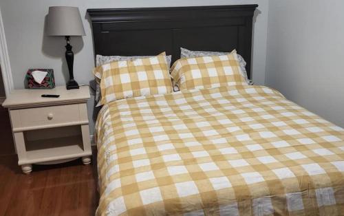 - un lit avec une couverture en damier et une table de nuit dans l'établissement Appartement assafa, à Nevers