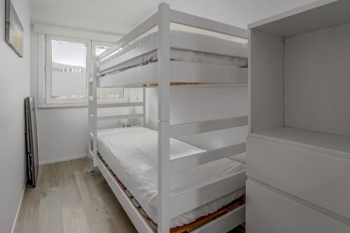 a white bunk bed in a room with a window at Rietpanne 0106 in Koksijde