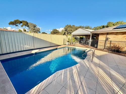 a swimming pool with a chair next to a house at South Bunbury Retreat in Bunbury