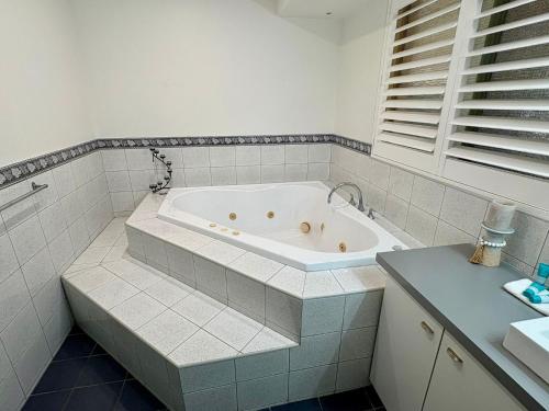 a white bathroom with a tub in a room at South Bunbury Retreat in Bunbury