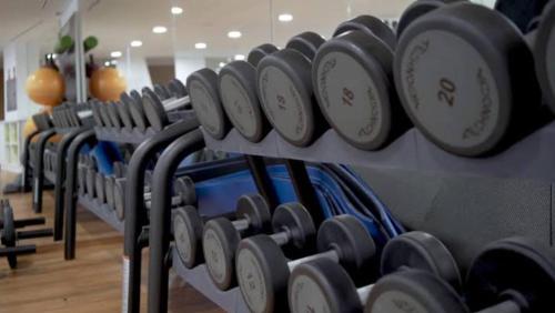 a row of dumbbells on a rack in a gym at Sunset Collection Del Mar in Playa del Carmen