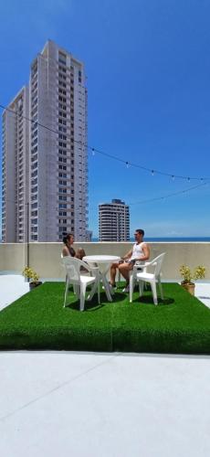 two men sitting at a table on top of grass at Room at the Sky and Roof Top in Panama City