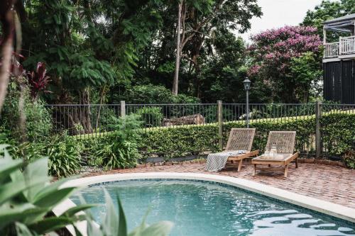 a swimming pool with two chairs and a table and a bench at Luxe Hinterland Stay, Eastnor at Montville Estate in Montville