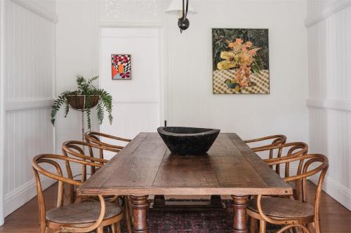 a dining room table with chairs and a bowl on it at Luxe Hinterland Stay, Eastnor at Montville Estate in Montville