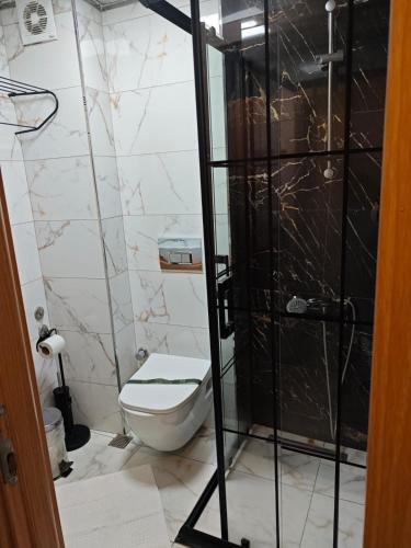 a bathroom with a toilet and a glass shower at Hotel Devman in Istanbul