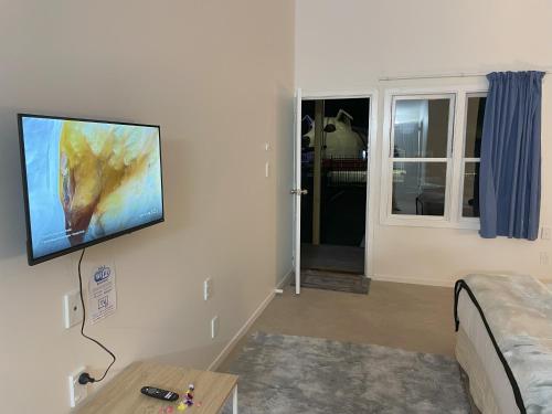 a living room with a flat screen tv on the wall at Tirau Motor Inn in Tirau