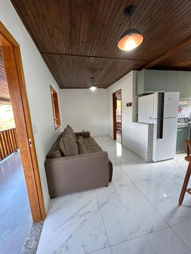 a living room with a couch and a refrigerator at Rancho do Léo in Conceição do Mato Dentro