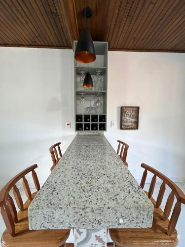 a dining room with a large table with chairs at Rancho do Léo in Conceição do Mato Dentro