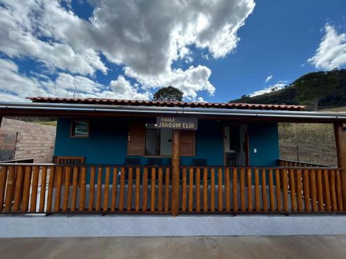 a blue house with a wooden fence in front of it at Rancho do Léo in Conceição do Mato Dentro