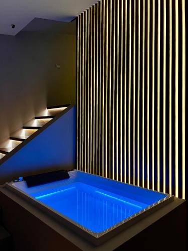 a blue tub in a room with a wooden wall at Renard Suite in Cefalù