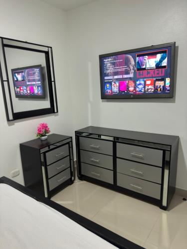 a bedroom with a dresser and a tv on the wall at Hermoso Apartamento en 3er nivel con terraza privada in Bonao