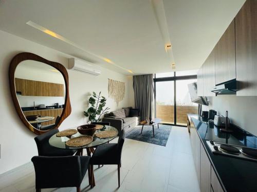 a living room with a table and a mirror at Oxygen! beautiful beach apartament 1BR Ocean view in Playa del Carmen