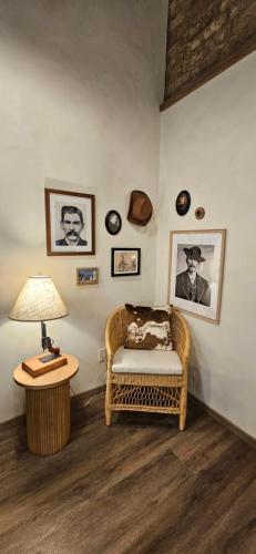 a living room with a wicker chair and a lamp at Inn History Tombstone in Tombstone
