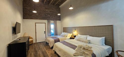 a hotel room with two beds and a television at Inn History Tombstone in Tombstone