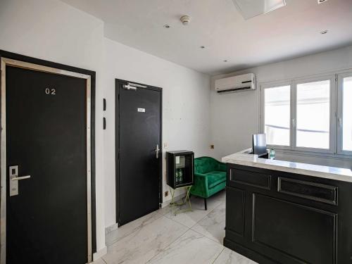 Cette chambre dispose d'une porte noire et d'une chaise verte. dans l'établissement Résidence AVATON Cannes Centre, à Cannes