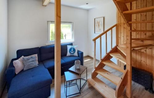 a living room with a blue couch and a staircase at Two-Bedroom Holiday Home In Podamirowo in Podamirowo