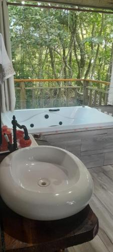 a bathroom with a white sink and a bath tub at chale opucv in Gonçalves