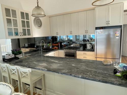 a kitchen with white cabinets and a granite counter top at Waves at Warilla in Barrack Point