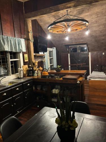 a kitchen with a table and a chandelier at Cabaña de Montaña 9per Aire Fresco & Naturaleza in Trojas