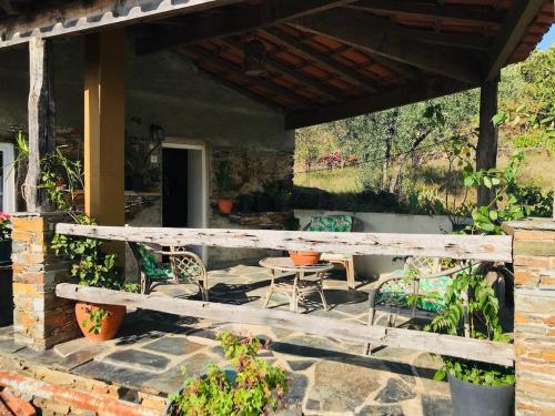 a patio with a wooden fence and chairs and a table at Escapada na Natureza - Charmoso Refúgio nas Alturas in Góis