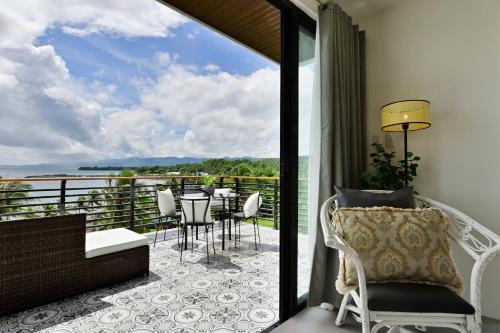 a room with a balcony with a table and chairs at Ogma Suites Legazpi in Legazpi