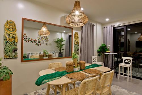 a dining room with a table and a mirror at Ogma Suites Legazpi in Legazpi