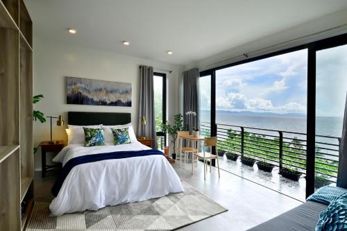 a bedroom with a bed and a view of the ocean at Ogma Suites Legazpi in Legazpi