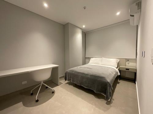 a small bedroom with a bed and a desk at Exclusivo Apartamento en Distrito 90 in Barranquilla