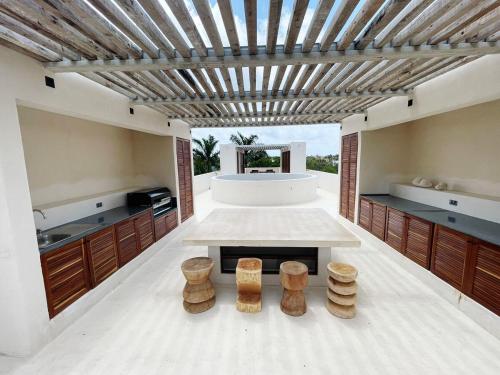 eine Küche mit einem Tisch und einigen Holzhockern in der Unterkunft Tulum Country club casa pokolpok in Chacalal