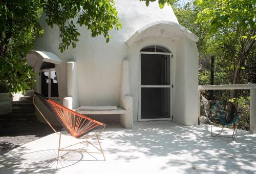 a pair of chairs sitting in front of a building at New Ruins Off-The-Grid SuperAdobe Domes with Pool in San Francisco de Abajo