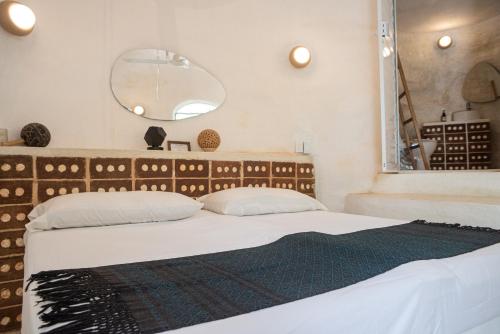 a bedroom with two beds and a large mirror at New Ruins Off-The-Grid SuperAdobe Domes with Pool in San Francisco de Abajo