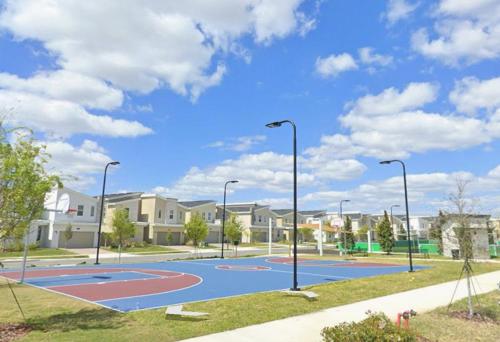 a basketball court in a park with street lights at Wonderful Disney-Themed Home in ChampionsGate Resort 15 min from Disney World with 7 pools, Club houses, Water Park, Gym, Arcades, Lazy River, Golf, and More! in Kissimmee
