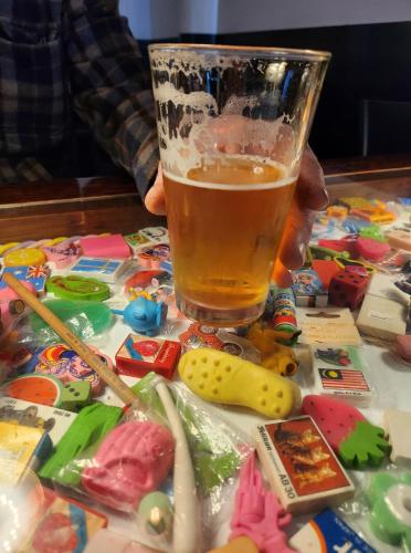 a glass of beer sitting next to a pile of toys at Tuatara Lodge in Invercargill