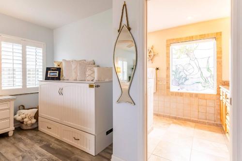 ein Badezimmer mit einem Spiegel und einem weißen Kühlschrank in der Unterkunft Salty Dog Direct Oceanfront Luxurious Retreat! in Indialantic