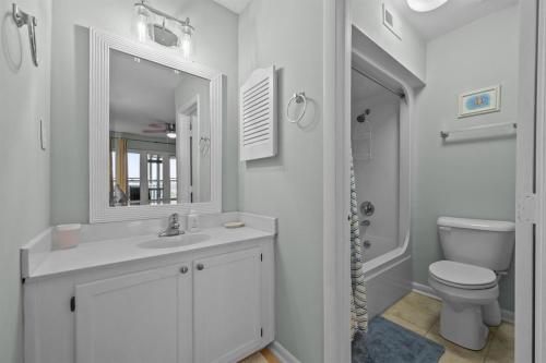 a white bathroom with a sink and a toilet at Sea La Vie- Oceanfront Family Retreat in North Topsail Beach