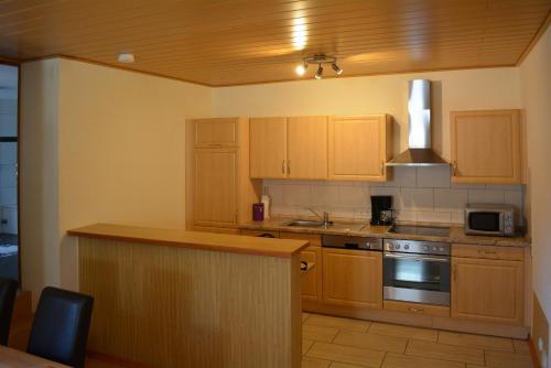 a kitchen with wooden cabinets and a stove top oven at Ferienwohnung Weber in Zell an der Mosel