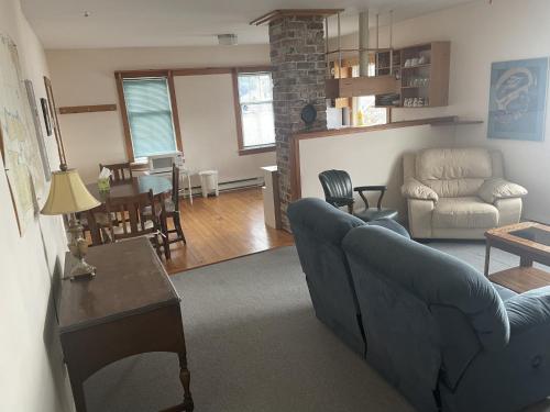 a living room with a blue couch and a table at Seine Boat Inn in Alert Bay