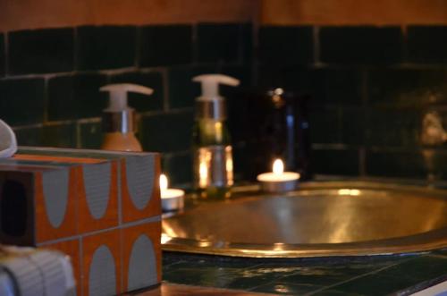 a bathroom sink with a candle on a counter at Behind js in Essaouira