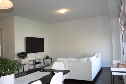 a living room with a white couch and a tv at Detached New Modern House In South Barrie - Built H plus ME Technology in Barrie