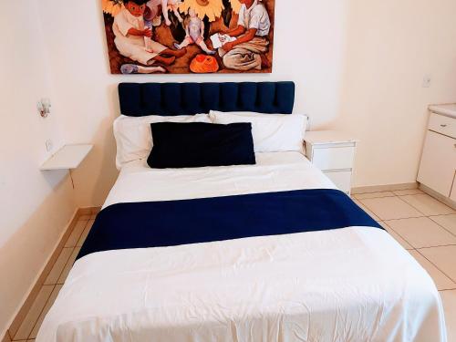 a bedroom with a large bed with a blue headboard at Departamento 14 comodo y centrico , cerca del vado del rio y de la zona comercial de Hermosillo in Hermosillo