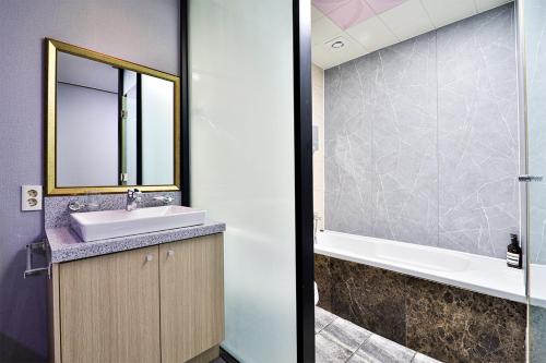 a bathroom with a sink and a mirror at Hotel Noah in Busan