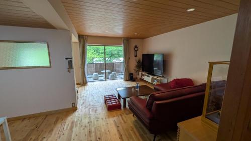 a living room with a couch and a flat screen tv at condominium SAKURA B5 in Hakone