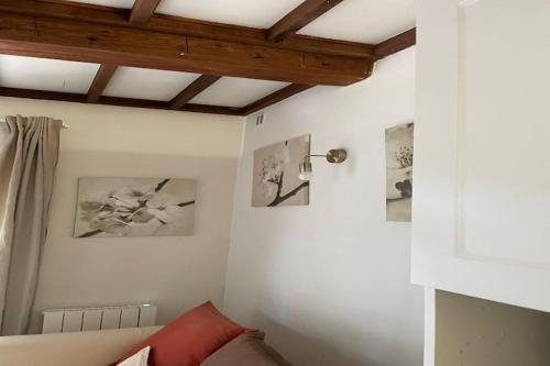 Cette chambre comprend un lit et des photos sur le mur. dans l'établissement Cottage in Bayeux near Tapestry Museum, à Bayeux