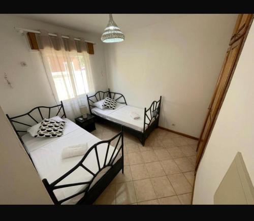 a room with two beds and a window in it at Villa dans Residence du Port in Saly Portudal