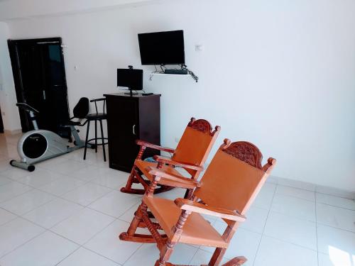 two rocking chairs sitting in a room with a tv at Departamento 14 comodo y centrico , cerca del vado del rio y de la zona comercial de Hermosillo in Hermosillo