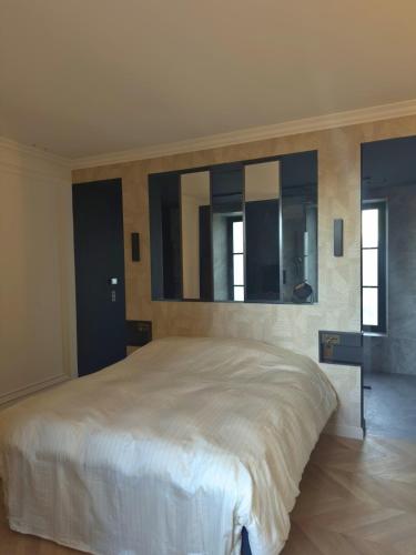 a bedroom with a large white bed and mirrors at Otentik Noblesse Royal View in Metz