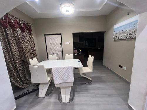 a dining room with a white table and white chairs at Minteh in Elephant Island