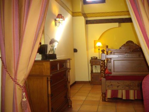 a bedroom with a bed and a dresser in a room at Hotel la Casa del Abuelo in Albarracín