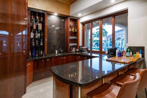 a bar with a counter and chairs in a room at Bellagio Gold Coast in Gold Coast