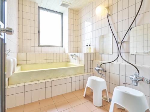 a bathroom with a tub and a sink at Hotel Fukui Castle - Vacation STAY 58692v in Fukui